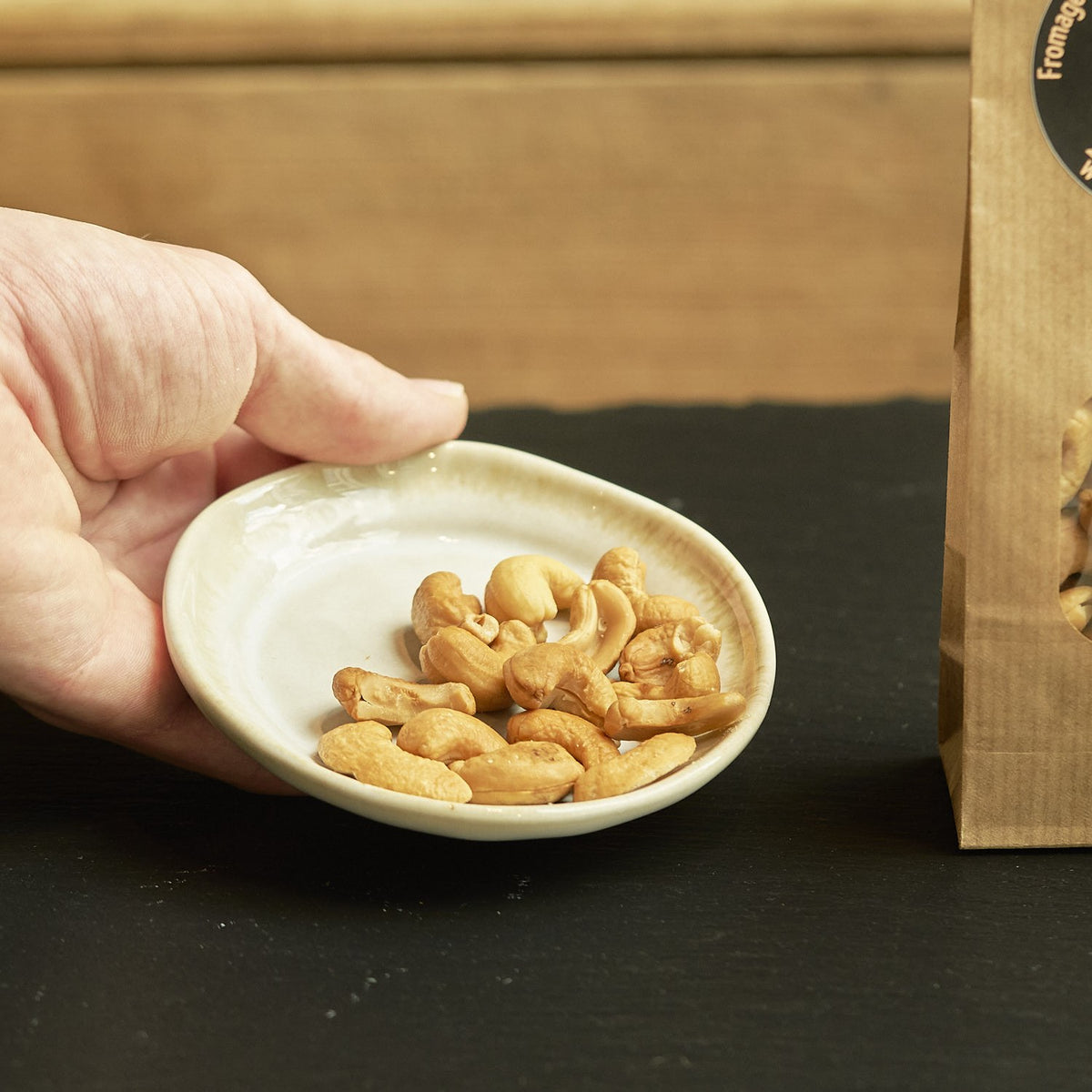 Geröstete Cashewkerne im Schälchen, von Hand gereicht