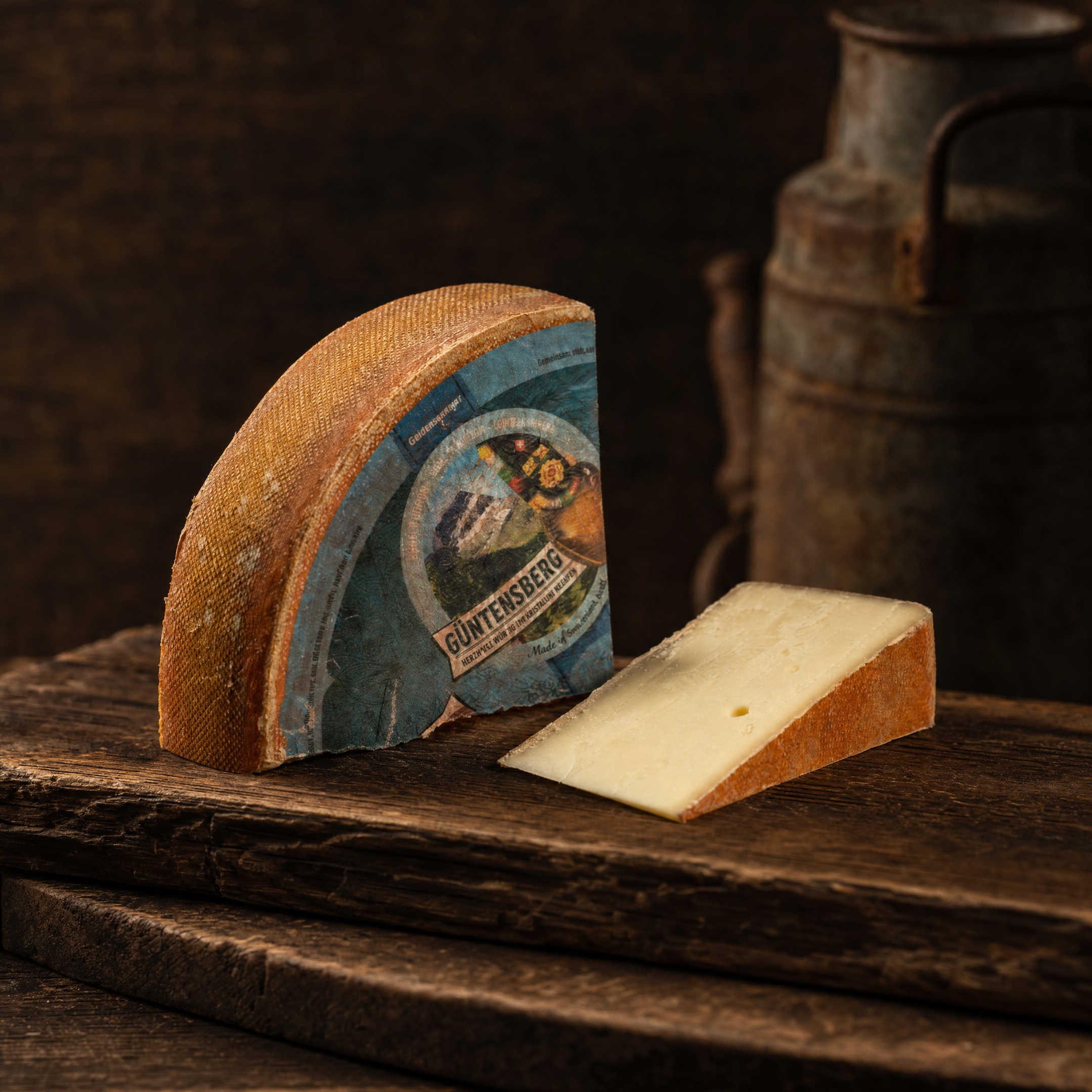 Güntensberg Hartkäse, Laib und Anschnitt, mit alter Milchkanne im Hintergrund