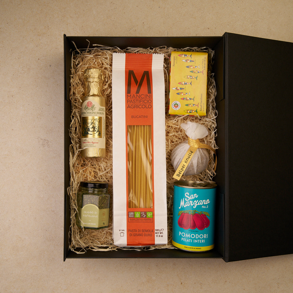 Geschenkbox Kochabend, geöffnet: Bucatini, San-Marzano-Tomaten, Sardinen, Origano, Olivenöl und Belper Knolle