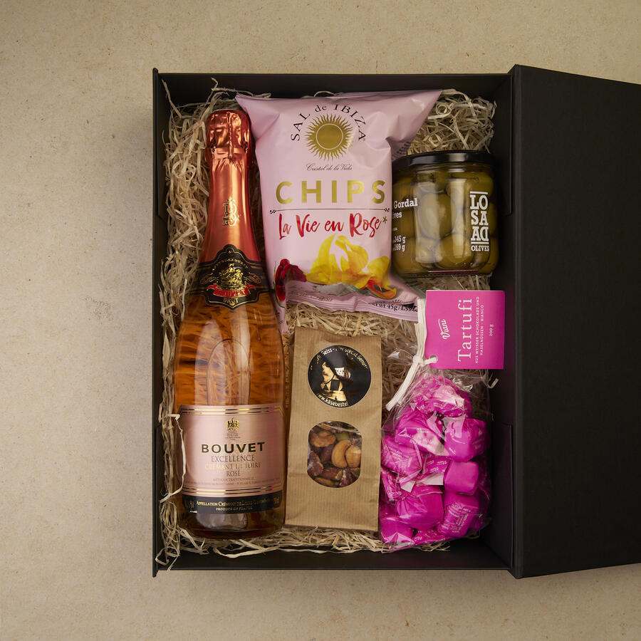 Geschenkbox Perlenmoment groß, geöffnet: Bouvet Crémant Rosé, Chips La Vie en Rose, Tartufi Panna Cotta, Gordal-Oliven und Nussmix