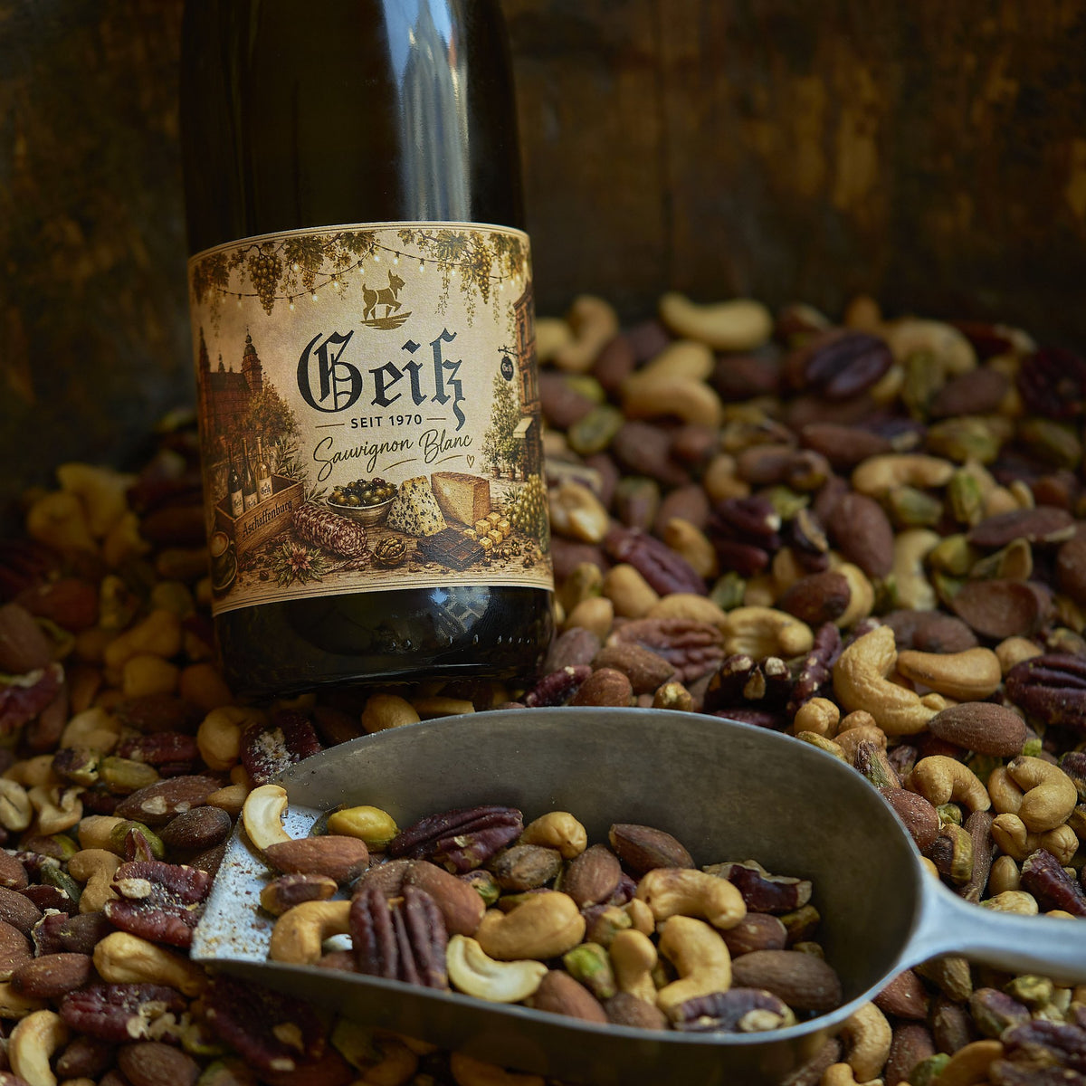 Nussmix Finest mit Nussschaufel und einer Flasche Geiß Sauvignon Blanc