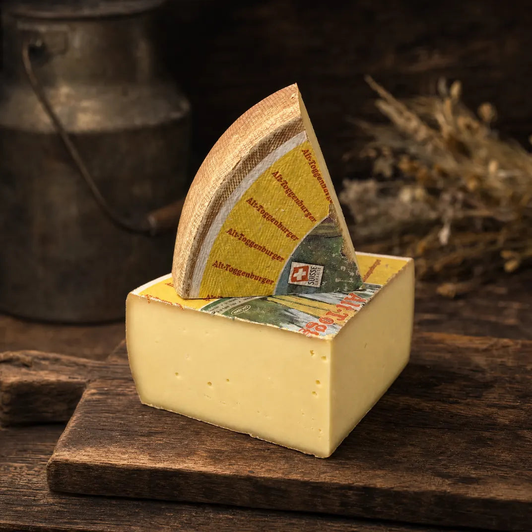 Alt Toggenburger – Hartkäse-Keil mit tiefgelber Farbe auf dunklem Holzbrett