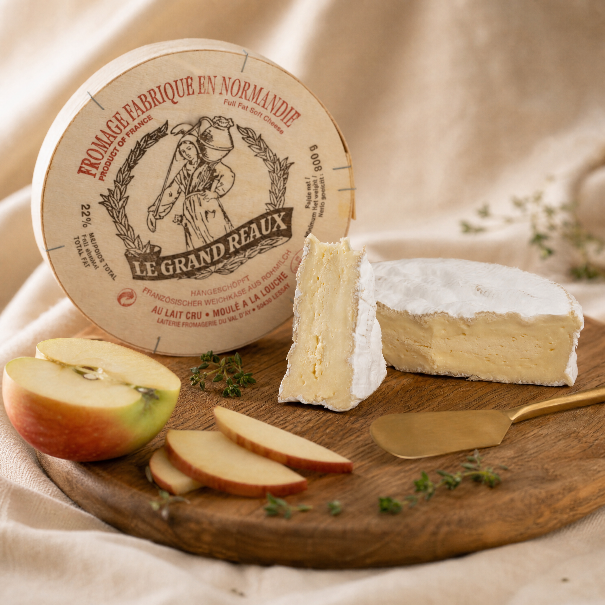 Camembert Fermier Le Grand Reaux – Laib mit Anschnitt und Schachteldeckel auf rundem Holzbrett