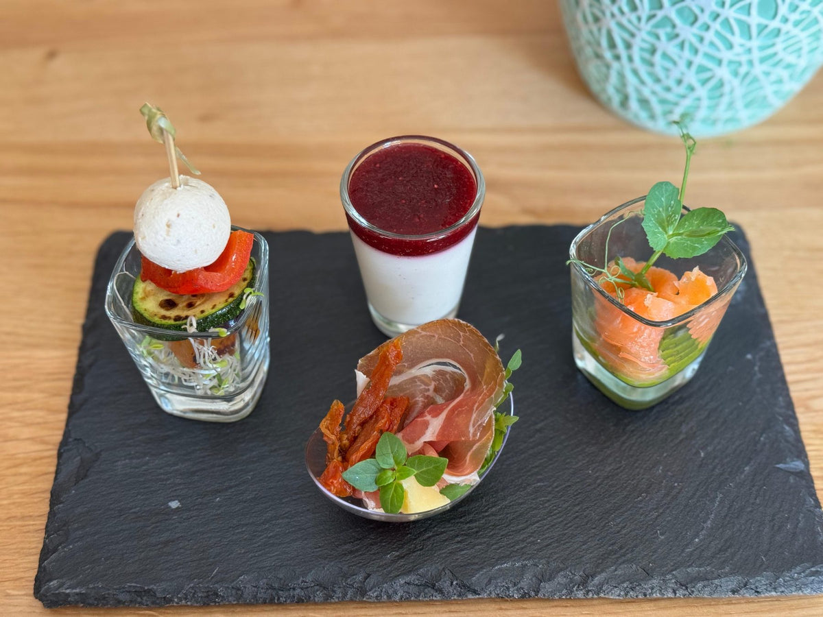 Fingerfood-Gläschen aus dem Catering der Fromagerie Geiß in Aschaffenburg, angerichtet auf einer Schieferplatte