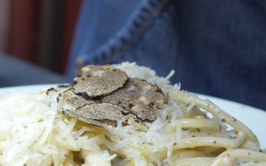 Teller mit Trüffelpasta, frisch gehobelte schwarze Trüffelscheiben obenauf