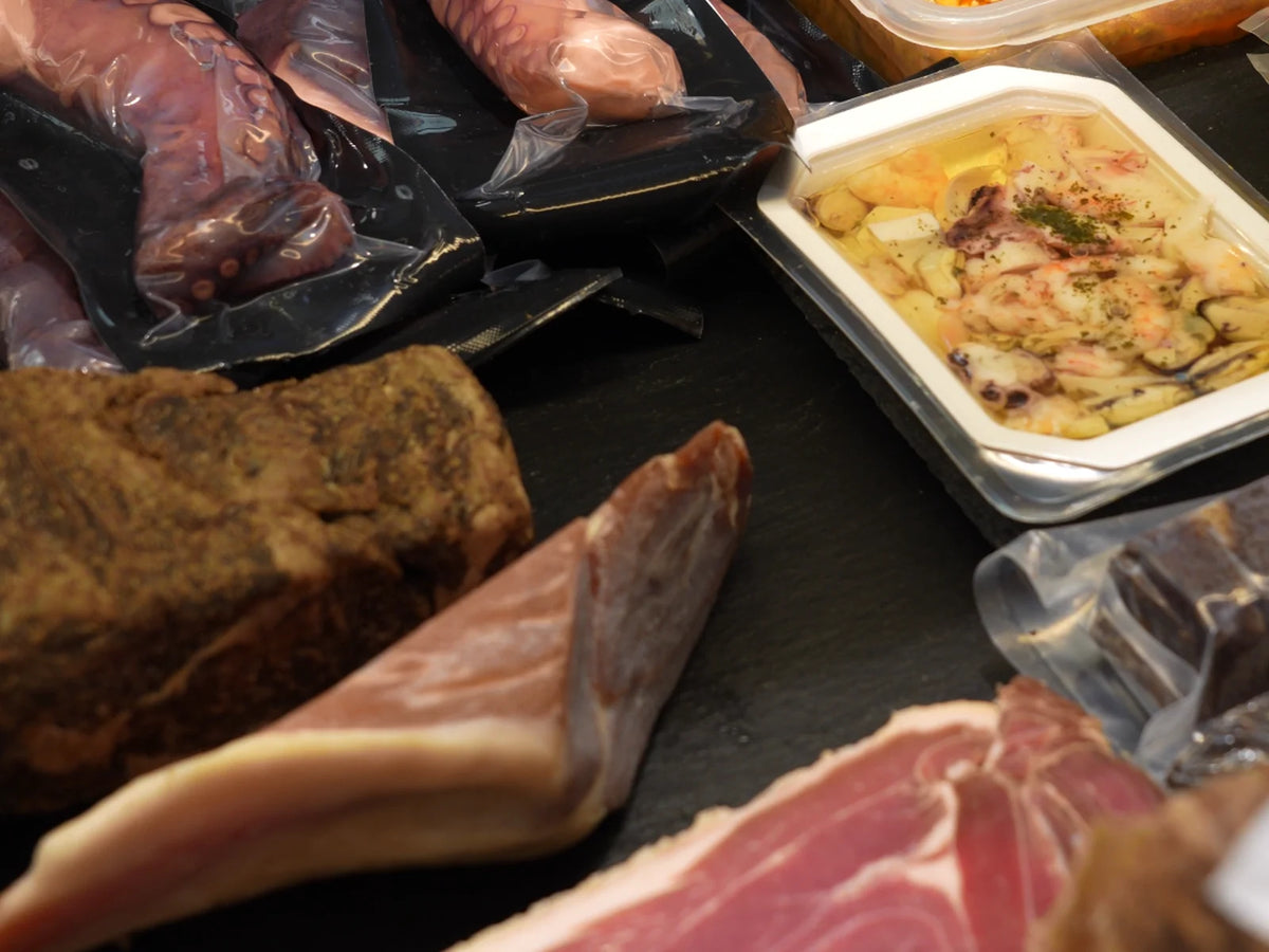 Feinkosttheke mit luftgetrocknetem Schinken, Salami, Pulpo und Antipasti