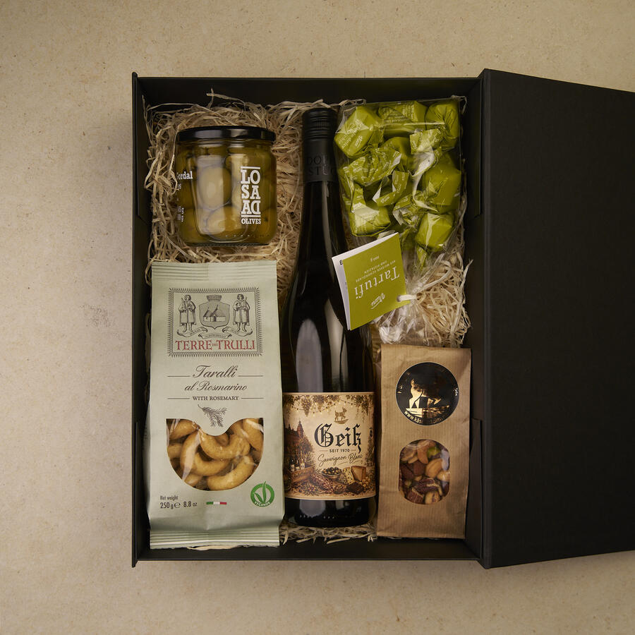 Geschenkbox Weingruß groß, geöffnet: Geiß Sauvignon Blanc, Taralli, Gordal-Oliven, Tartufi Pistacchio und Nussmix auf Holzwolle