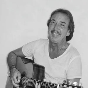 Chill mit Dill sitzt mit Gitarre da und singt, Schwarzweiß.